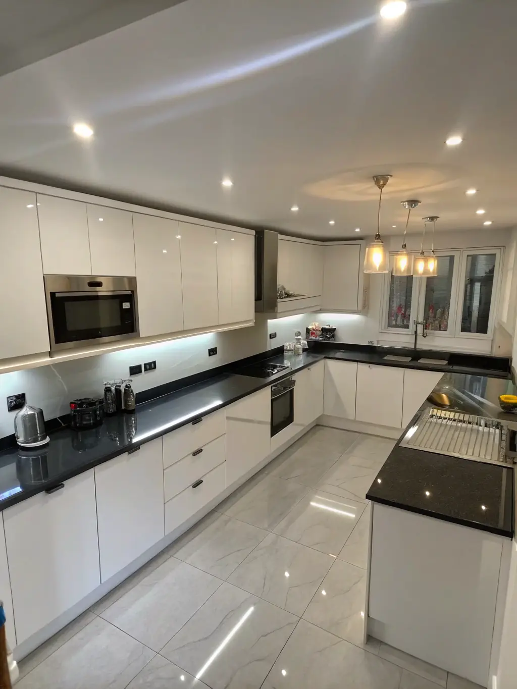 A beautifully remodeled kitchen with white cabinets, granite countertops, and stainless steel appliances, showcasing Portland Remodeling Crew's kitchen renovation expertise.